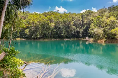 Blue-green waters of Lake Eacham surrounded by dense rainforest in the Atherton Tablelands, Queensland.