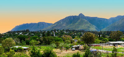 Wide landscape view of Swellendam surrounded by green farmland and the Langeberg mountain range in the Western Cape.