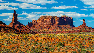Red sandstone buttes and desert plains along the scenic drive in Monument Valley, Southwest United States.
