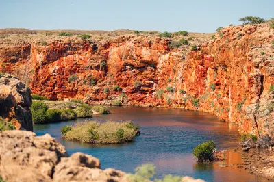 Red limestone cliffs rise above the blue waters and mangroves of Yardie Creek Gorge.