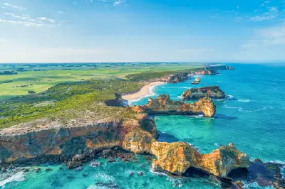 Aerial view of limestone headlands, rocky outcrops, turquoise coves and farmland around Childers Cove, Victoria.