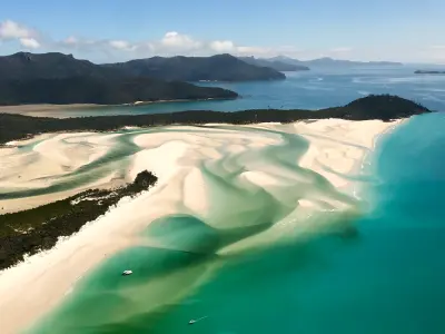 Aerial view of swirling white sandbanks and turquoise water at Hill Inlet beside Whitehaven Beach, Whitsunday Island, Queensland.