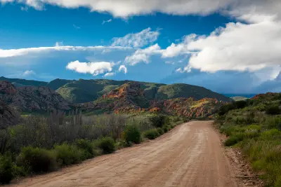Gravel road through the Red Stone Hills near Calitzdorp in the Little Karoo with red rock formations and semi-arid Karoo landscapes in South Africa