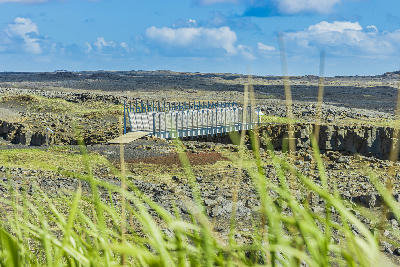 Metal footbridge crossing a tectonic fissure at the Bridge Between Continents on the Reykjanes Peninsula, Iceland.