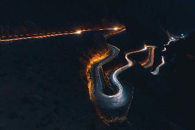 Night light trails following the winding hairpin bends of Dades Gorge Road in Morocco’s High Atlas canyon landscape