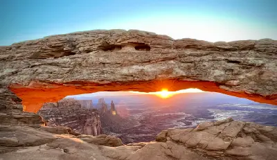 Mesa Arch framing sunrise over canyon cliffs in Canyonlands National Park Utah