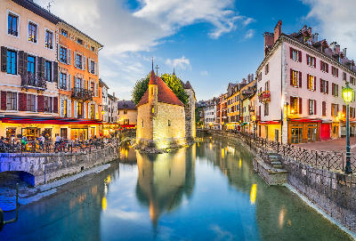 Thiou River in Annecy with turquoise water, canalside buildings, and Château d’Annecy rising above the old town