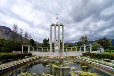 Huguenot Monument and reflecting pool under stormy skies in Franschhoek in the Cape Winelands of South Africa.