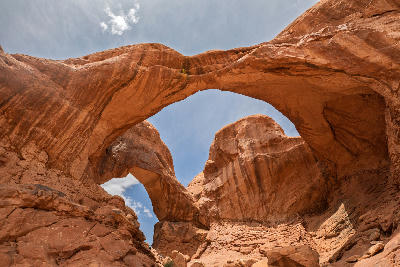 View from below of Double Arch showing sandstone spans and rock texture in Arches National Park Utah