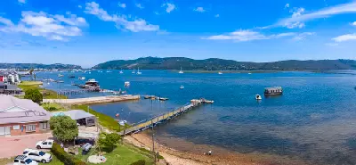View across Knysna Lagoon showing boats, jetties and waterfront development, with Thesen Island and the estuary stretching toward The Heads in the Garden Route, South Africa.