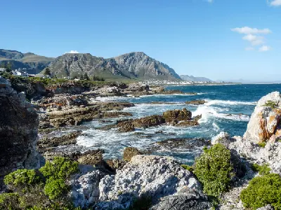 Rocky coastline and mountain backdrop at Fernkloof Nature Reserve near Hermanus along Walker Bay in the Western Cape