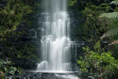 Close view of Triplet Falls cascading over dark moss-covered rock in Great Otway National Park, Victoria.