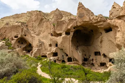 Historic rock-cut monastery with large cave chambers and fairy chimney formations at Zelve Open Air Museum in Cappadocia, Turkey.