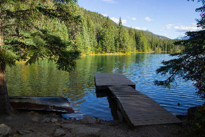 Wooden dock extending into a forest lake at Valley of the Five Lakes, Jasper National Park