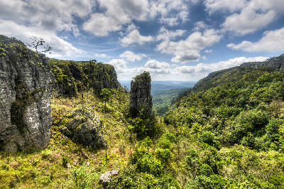 Pinnacle Rock rising from a forested escarpment valley between quartzite cliffs on the Panorama Route near Graskop, Mpumalanga, South Africa.
