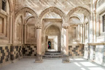 Carved stone arches and columns inside an ornate courtyard at İshak Pasha Palace in Eastern Turkey.