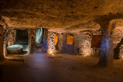 Interior of Derinkuyu Underground City showing carved chambers, passages and a large circular stone in Cappadocia, Turkey.