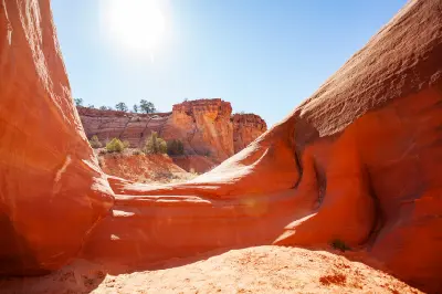 Sunlit red sandstone walls and sculpted rock formations near Zebra Slot Canyon, Utah.