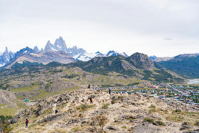People standing at Mirador de los Cóndores viewpoint above El Chaltén with Fitz Roy peaks in the background, Patagonia, Argentina.