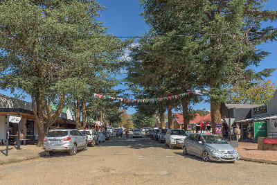 Main street in Clarens lined with shops, restaurants and large trees in the Eastern Highlands of the Free State.