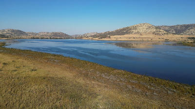 Wetland lake surrounded by grassland and volcanic hills in Pilanesberg National Park, South Africa.