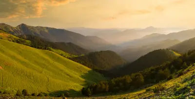 Golden sunset over green mountain slopes and layered ridges of the Zigana Mountains, viewed from Saranoy Plateau in northern Turkey.