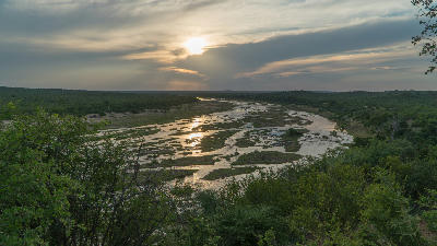 Panoramic sunset view over a braided river channel flowing through the wilderness landscapes of central and northern Kruger National Park, South Africa.