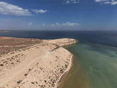 Aerial view of the sandy Eagle Bluff headland, boardwalk and shallow turquoise waters of Henri Freycinet Harbour.
