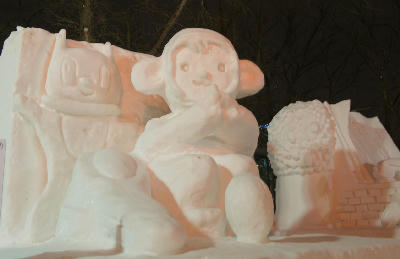 Snow sculpture of cartoon characters displayed at night during the Sapporo Snow Festival in Odori Park, Sapporo, Japan.