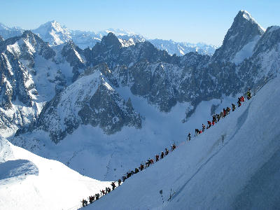 Alpinists and skiers descending the steep Aiguille du Midi ridge above the Vallée Blanche glacier in Chamonix.