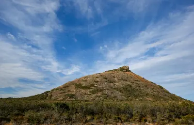 Granite dome of Frenchman Peak rising above coastal heath in Cape Le Grand National Park, Western Australia.