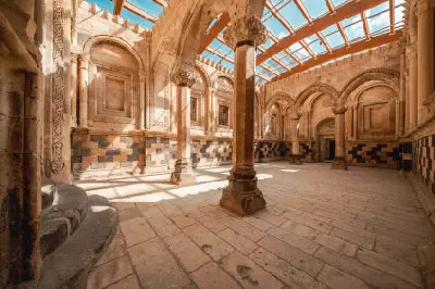 Ornate stone courtyard with carved arches and columns inside İshak Pasha Palace in Eastern Turkey.