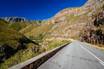 Mountain road passing through steep rocky slopes in Tradouw Pass near Barrydale in the Western Cape of South Africa.