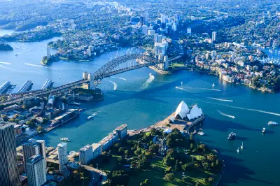 Aerial view across Sydney Harbour showing the Opera House, Harbour Bridge, Circular Quay, ferries and the North Sydney shoreline.