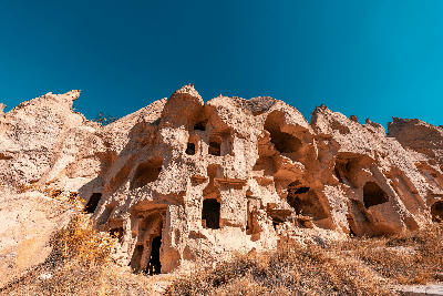 Historic cave dwellings and rock-cut monastic buildings carved into volcanic tuff at Zelve Open Air Museum in Cappadocia, Turkey.