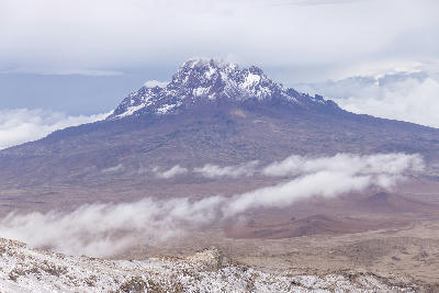 Mawenzi Peak (5,149 m) viewed across the Saddle on Mount Kilimanjaro, Tanzania, with clouds drifting over the high-altitude volcanic plateau at approximately 4,700 metres above sea level.