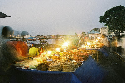 Food stalls illuminated by lanterns at the lively evening market in Forodhani Gardens, Stone Town, Zanzibar.