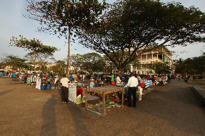 Vendors setting up the evening food market beneath large trees at Forodhani Gardens in Stone Town, Zanzibar.