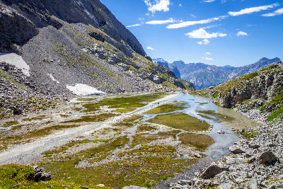 Stepping stone path across the shallow waters of Lac des Vaches in Vanoise National Park