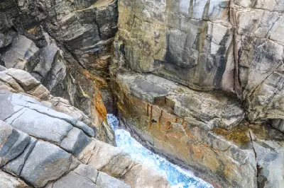 Looking down into the narrow granite chasm of The Gap with ocean water below in Torndirrup National Park near Albany, Western Australia.