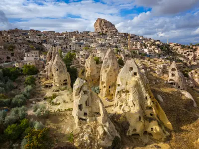 Uçhisar Castle overlooking rock-cut fairy chimneys and Uçhisar village in Cappadocia, Turkey.