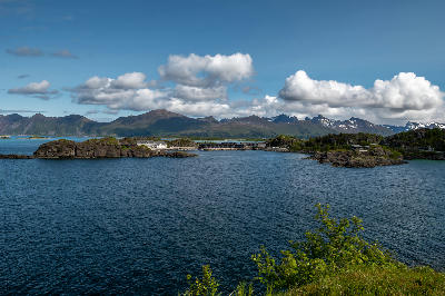Hamn i Senja village across a fjord with rocky islets and mountains on Senja island, Norway