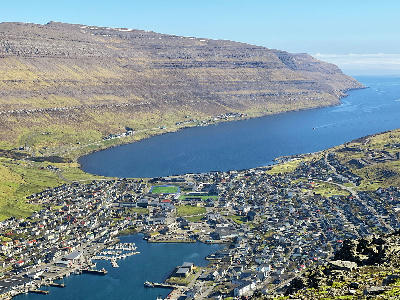 Overhead view of Klaksvík showing harbour, marina and town streets surrounded by steep basalt mountains on Borðoy, Faroe Islands.