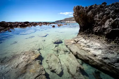 Clear shallow rock pools with submerged boulders beside rugged coastal rocks at Stokes Bay, Kangaroo Island, South Australia.