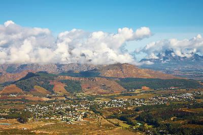 Elevated landscape view of Franschhoek Valley with vineyards, mountain ranges, and rural settlements in the Cape Winelands of South Africa.