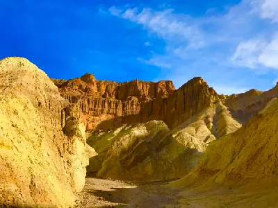 Golden Canyon in Death Valley National Park California with yellow badlands walls leading to Red Cathedral rock formations