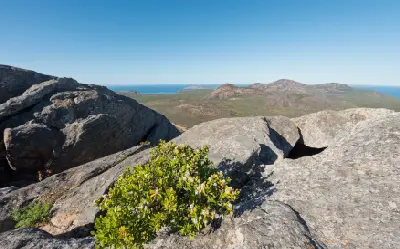 View across granite boulders and coastal hills from the Frenchman Peak summit trail in Cape Le Grand National Park, Western Australia.