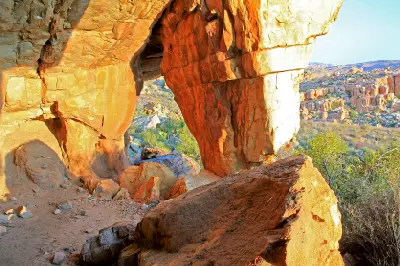 Interior view of a sandstone cave at Stadsaal in the Cederberg with weathered rock formations and valley landscapes beyond.