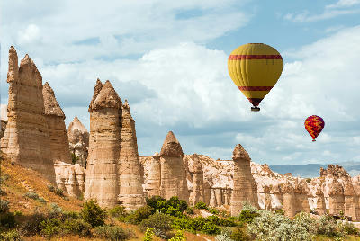 Love Valley with a hot air balloon drifting above the valley in the Cappadocia region of Turkey.