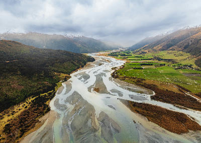 Makarora River flowing through farmland, South Island, New Zealand